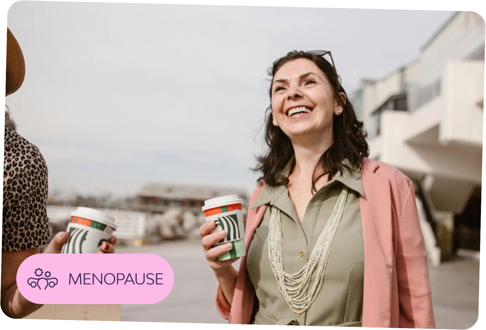 Smiling woman holding a coffee cup — representing confident support through menopause