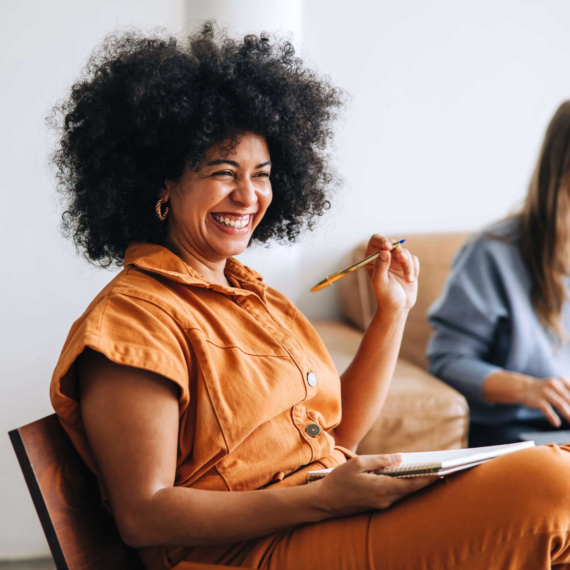 Woman seated with a notepad and pen, symbolising planning and personalised menopause care